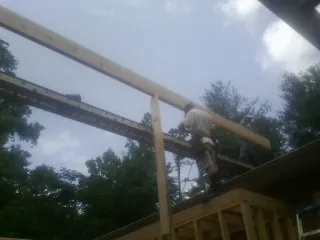 Carpenter setting a ridge beam over a new addition frame — Ice Dam Removal by Roofing Brothers in Pescadero